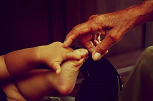 Mano di un nonno che tocca la piccola mano di un bimbo